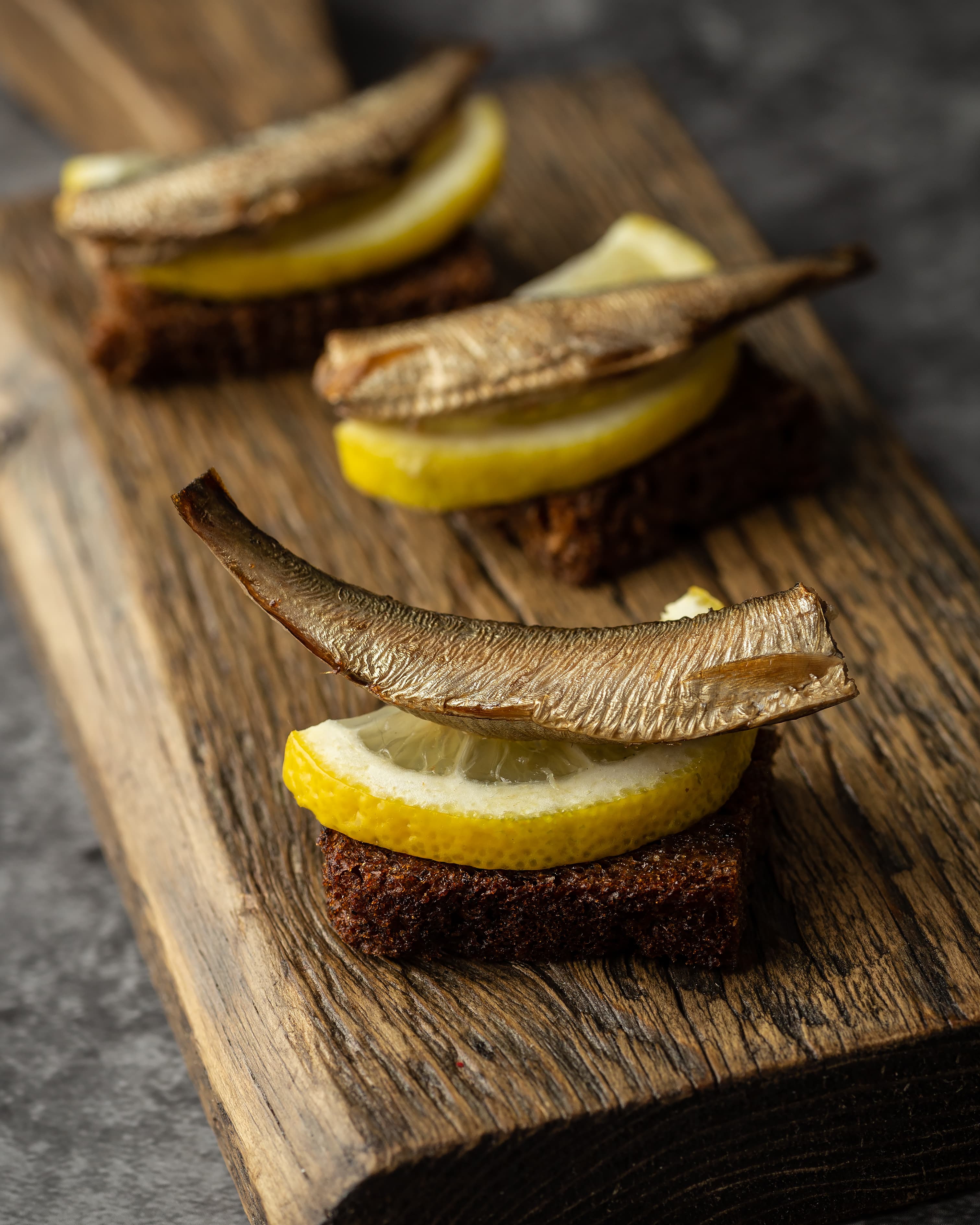Traditionally smoked sprats served on rye bread with lemon